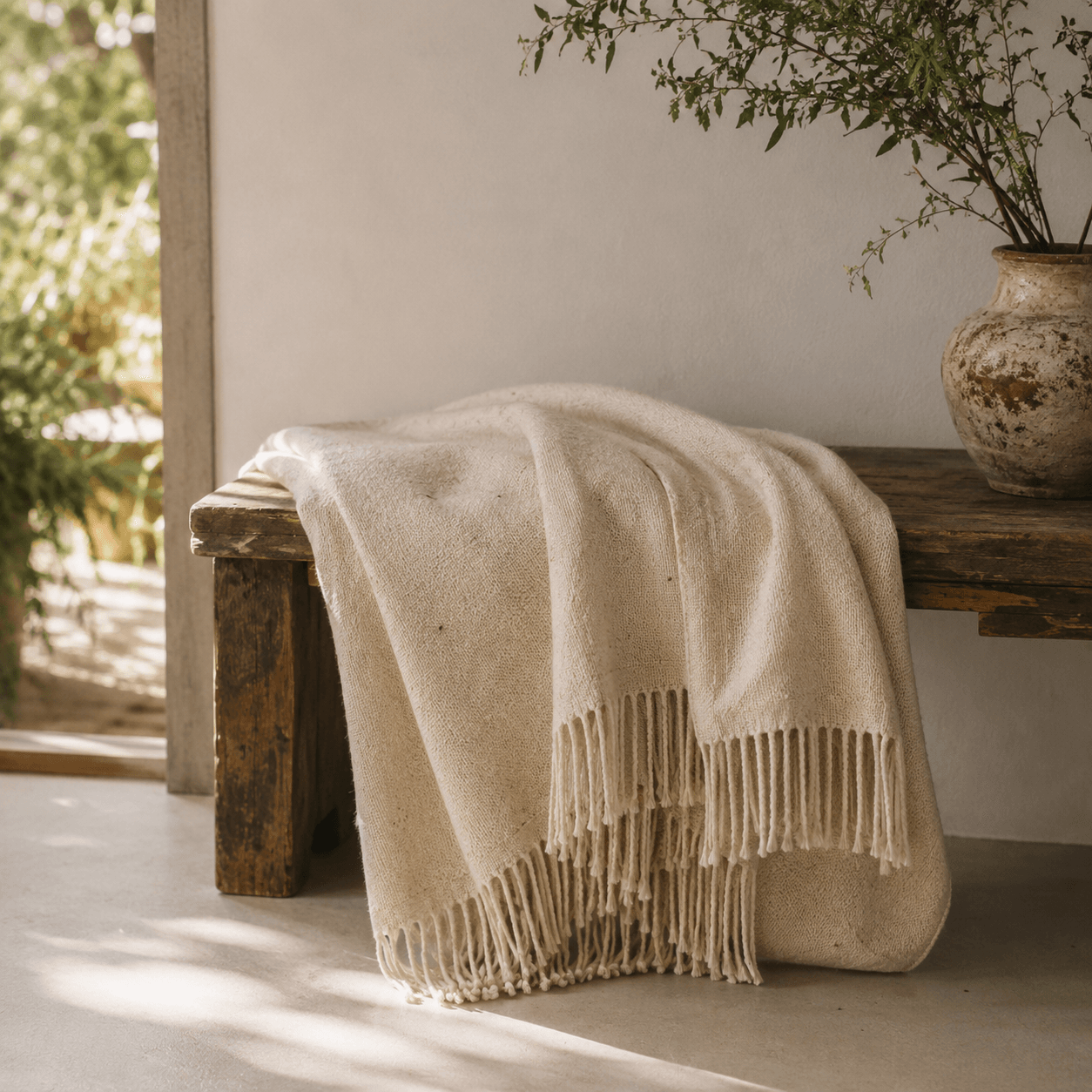 Plaid artisanal en laine écrue dans une ambiance méditerranéenne en Provence